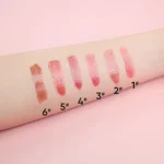 Several lipstick shades displayed against a soft pink background