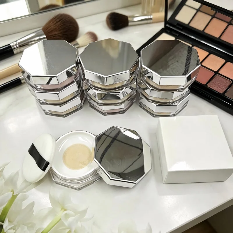 Soft powder puff beside a loose setting powder case Loose makeup powder with a soft-focus finishing effect