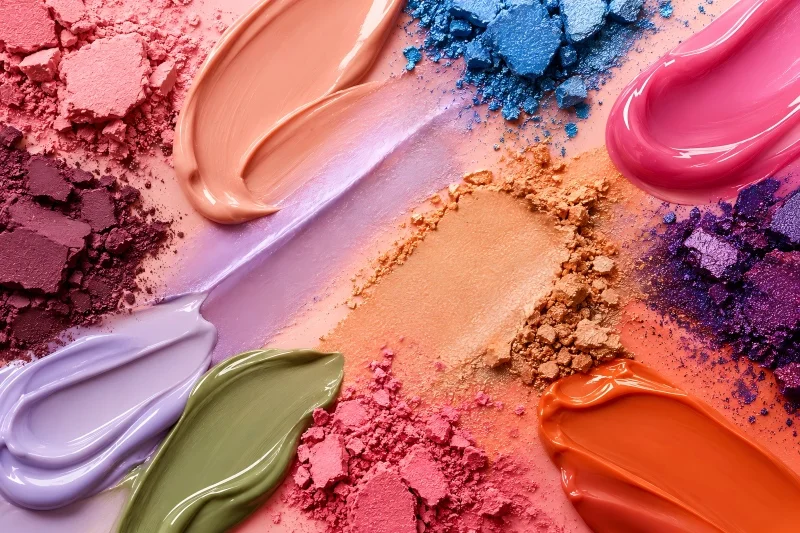Colorful eyeshadow pigments in matte, shimmer, and creamy textures for custom eye makeup.